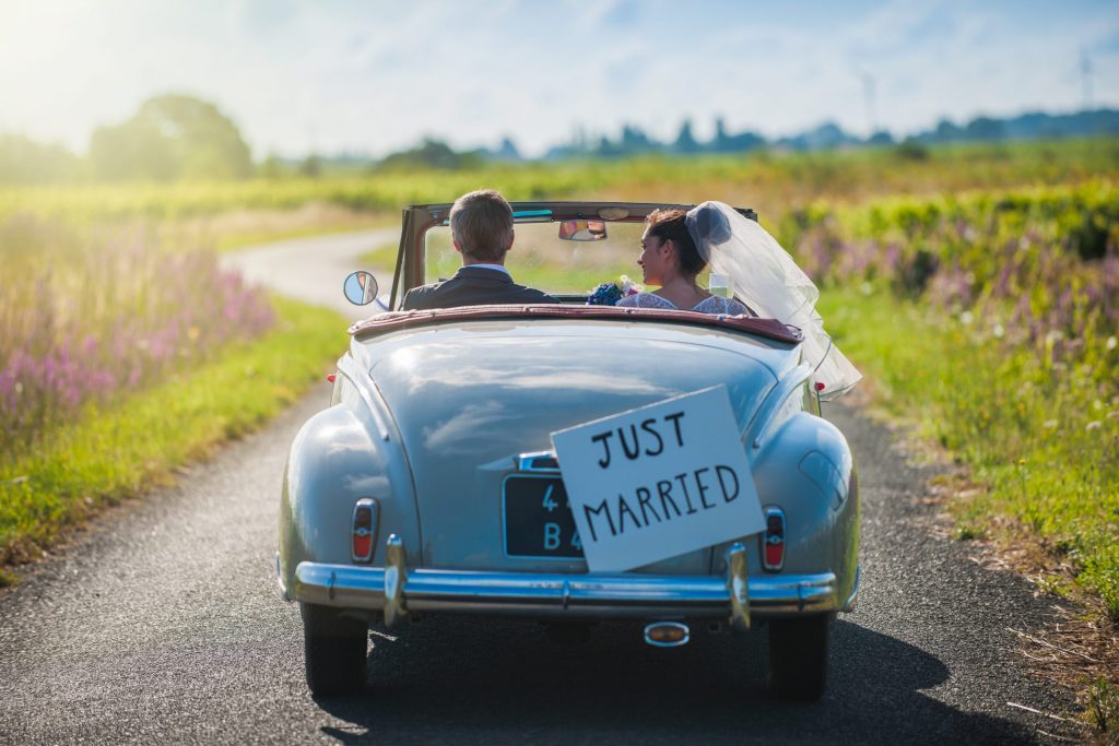 a,newlywed,couple,is,driving,a,convertible,retro,car,on
